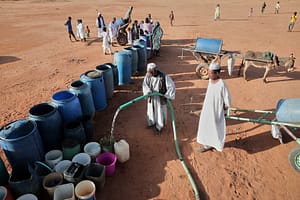 يتجمع مواطنون لملء أوعية المياه في إحدى نقاط توزيع المياه، بسبب انقطاع الإمداد المائي في الخرطوم، يوم الجمعة 30 يناير 2026. (صورة أسوشيتد برس/مروان علي)
